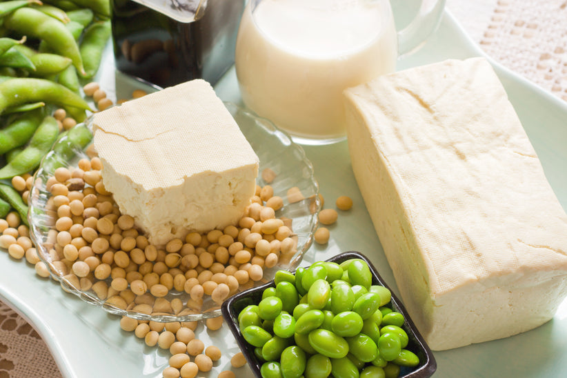 Top shot of a bowl of soy beans, glass of soy milk, and edamame