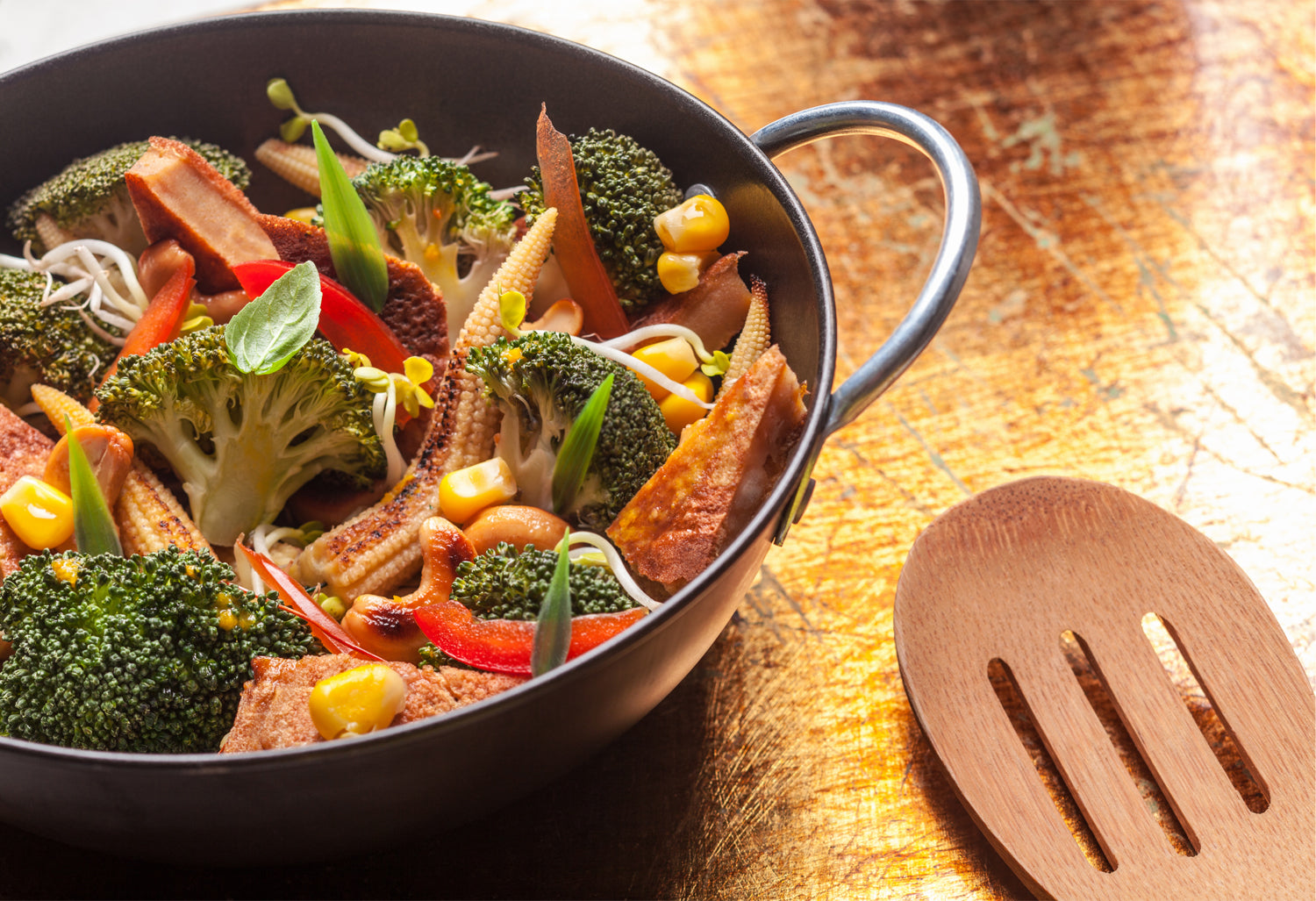 pan with vegetables in it and a wooden spoon