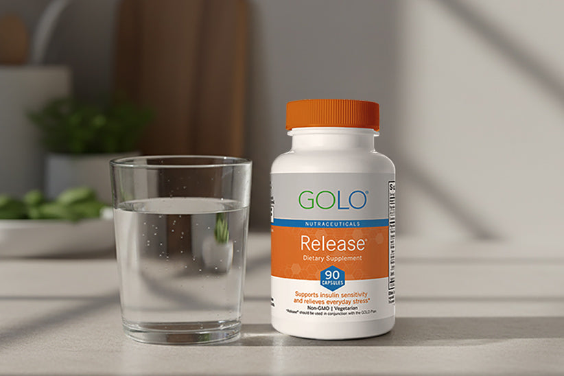 A bottle of release next to a glass of water on a kitchen counter. 