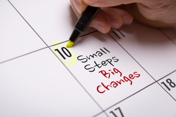 Person writing Small steps, big changes into a calendar