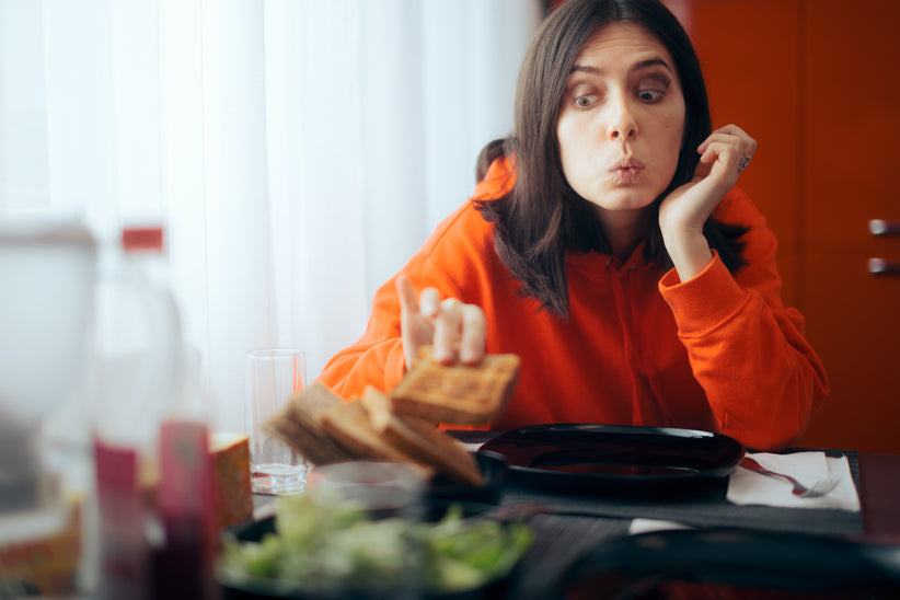 Woman picking up piece of bread