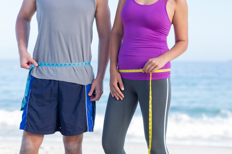 People measuring their waists