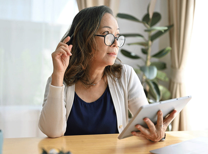 Woman looking at a tablet while sitting at a desk