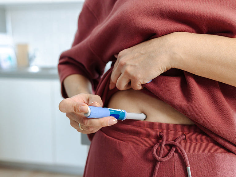 Woman giving herself a GLP-1 injection in her stomach