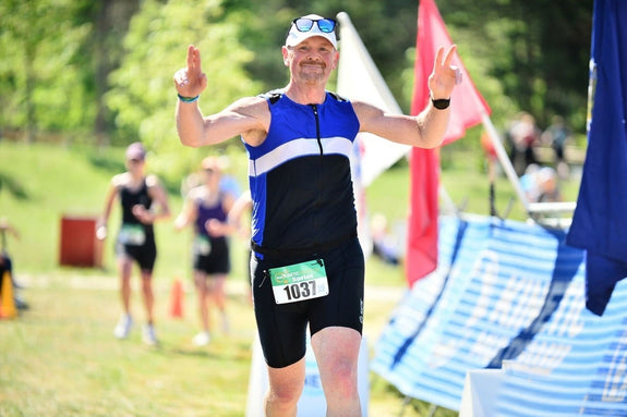 Jason crossing the finish line of a triathlon 