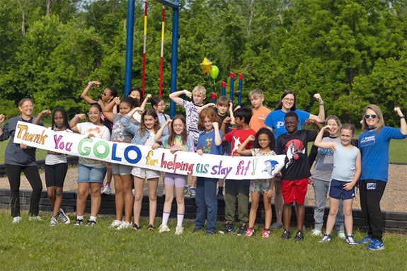 Group of students from John R. Downes Elementary School, plus GOLO President Jennifer Brooks and teachers from the school, holding a banner that says 'Thank you GOLO for helping us stay fit!' 
