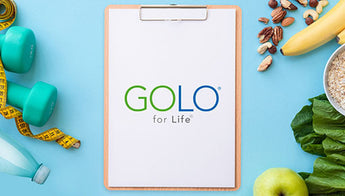 GOLO for life on a clip board, with some healthy foods, water, and weights surrounding it.