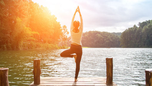 woman doing yoga on a dock